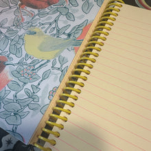 Load image into Gallery viewer, Notebook with peach colored pages and a floral pattern on the cover
